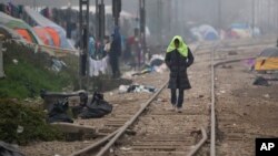A migrant man walks on railway tracks with a towel on his head at the northern Greek border point of Idomeni, Greece, March 18, 2016.