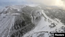 Sebuah stasiun kereta gantung, di mana para pemain ski sedang menunggu penyelamatan, dan gunung berapi yang meletus di pegunungan Kusatsu-Shirane terlihat dari helikopter Kyodo News di Prefektur Gunma, barat laut Tokyo, Jepang 23 Januari 2018. (Foto: Kyodo via REU)