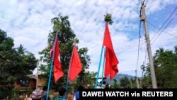Demonstrators carry flags as they protest the military coup in a village in Launglon township, Myanmar, April 9, 2021. (Courtesy of Dawei Watch/via Reuters)