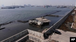 This aerial view shows a sea wall used to prevent sea water from flowing into Jakarta, Indonesia, July 27, 2019. Indonesia's president wants the speedy construction of the giant sea wall to save the low-lying capital of Jakarta from sinking under the sea.