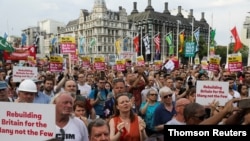 Supporters for Britain's opposition Labour Party leader Jeremy Corbyn hold placards during a rally calling for a general election in London, July 25, 2019.