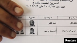 An Egyptian expatriate displays his ballot before casting his vote.