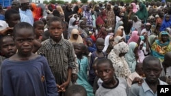 FILE - In this Tuesday Sept. 9, 2014 file photo, civilians who fled their homes following an attack by Islamist militants in Bama, take refuge at a school in Maiduguri, Nigeria. Attacks by Islamic extremist group Boko Haram in northeastern Nigeria and neighboring countries have forced more than 1 million children out of school.