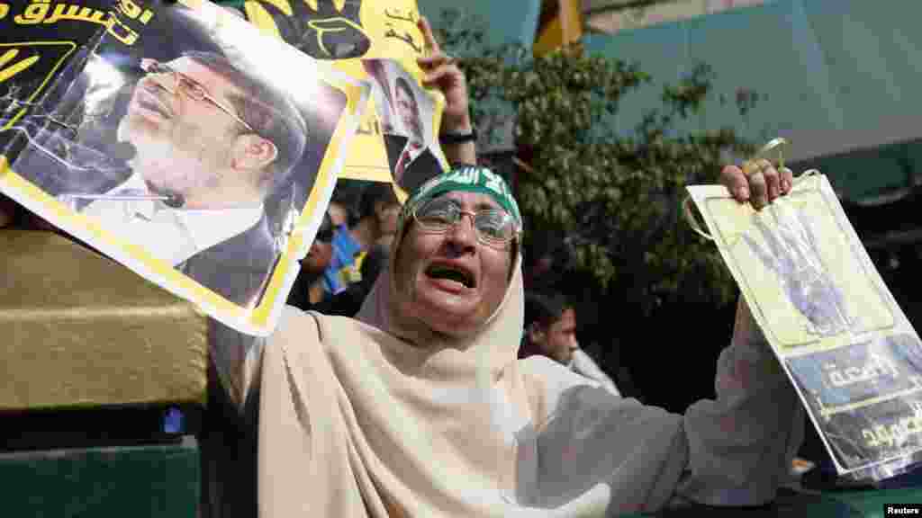 A supporter of ousted Egyptian president Mohamed Morsi cries while holding his poster, Cairo, Nov. 4, 2013. 