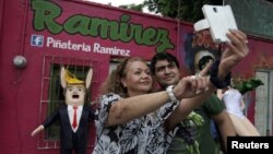 Un selfie junto a la piñata de Donald Trump en México.