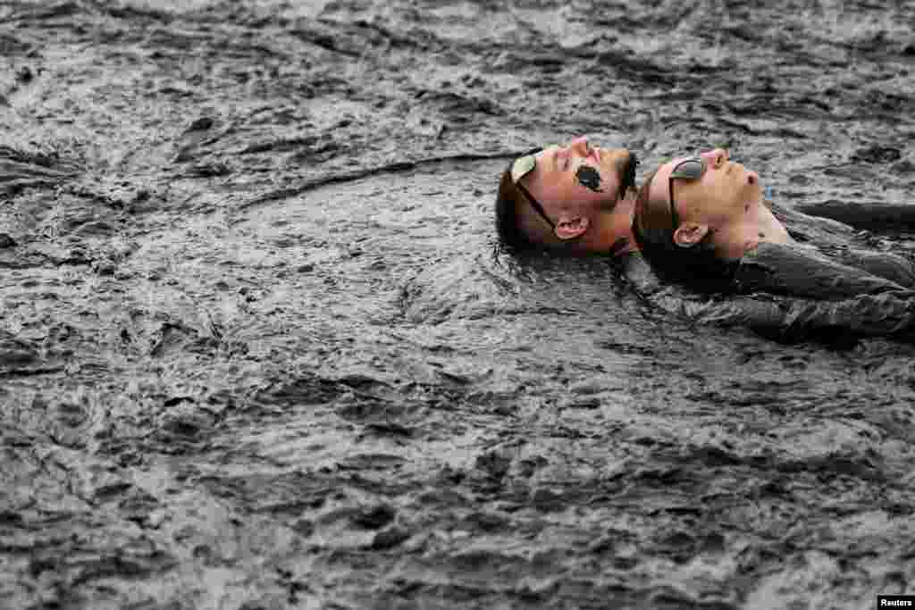 People take a mud bath during the &quot;Iron Mud&quot; festival in the town of Zheleznovodsk, in Stavropol region, Russia, Aug. 24, 2019.