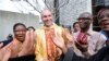 FILE - French Catholic priest Georges Vandenbeusch (C), former hostage in Cameroon, is applauded by parishioners in front of the Sainte-Genevieve-et-Saint-Maurice Cathedral in Nanterre, outside Paris.