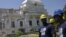 Workers from U.S. actor and Haiti's ambassador-at-large Sean Penn's charity J/P HRO (J/P Haitian Relief Organization) stand in front of the collapsed cupola of the condemned National Palace in Port-au-Prince, September 07, 2012. 