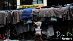 A woman, member of Brazil's Movimento dos Sem-Teto walks next to a set up camp on Paulista Avenue, during a protest to demand affordable low-income housing from the government, in front of the Office of the Presidency of the Republic in Sao Paulo, Brazil, March 7, 2017.