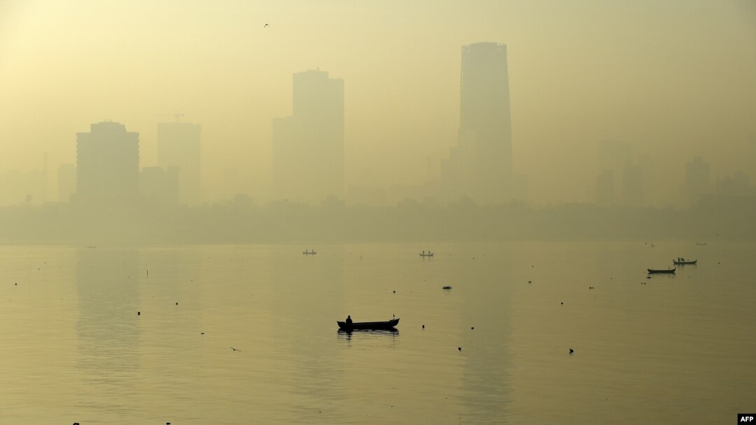 A fishing boat is seen in the morning general view of the city skyline covered by a smoggy haze in Mumbai, India, Jan. 29, 2016. 