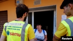 Psychologists volunteering in the aftermath of deadly floods speak to a woman in Catarroja, Valencia, Nov. 11, 2024.