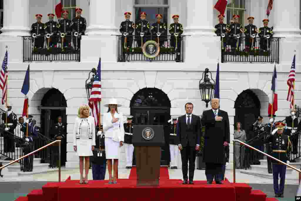 President Donald Trump and first lady Melania Trump stand with French President Emmanuel Macron and his wife Brigitte Macron during a State Arrival Ceremony on the South Lawn of the White House, April 24, 2018, in Washington. 