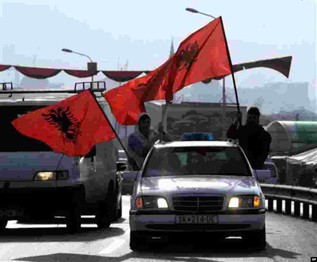 Ethnic Albanians wave Albanian flags from a vehicle, on a street in Skopje, Macedonia Sunday, Nov. 25, 2012 at the start of celebrations to mark the 100th anniversary of Albania's independence from the Ottoman empire. Some politicians have opposed such c