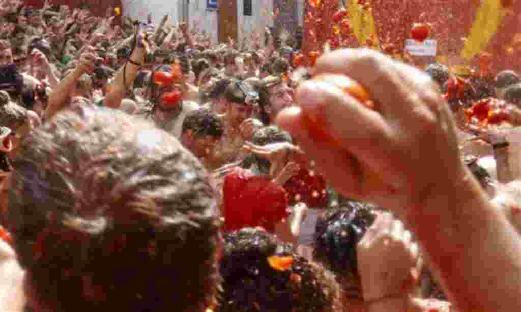Gente de todas partes del mundo se lanza tomates durante la celebración de la 'Tomatina' en el pueblo de Buñol, cerca de Valencia, España.