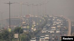 FILE - Traffic moves on a smoggy morning in New Delhi, India, October 23, 2020.