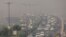 FILE - Traffic moves on a smoggy morning in New Delhi, India, October 23, 2020.