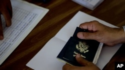 Seorang pria menunjukkan paspor Amerika di pusat pelaporan di Islamabad, Pakistan, 29 Juli 2010. 