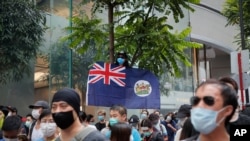 FILE - A man displays the Hong Kong colonial flag on the anniversary of Hong Kong's handover to China from Britain, in Hong Kong, July 1, 2020.
