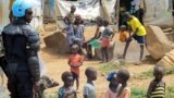 FILE - A U.N. peacekeeper keeps watch as children gather in a camp for displaced civilians in Juba, South Sudan, June 17, 2017. 