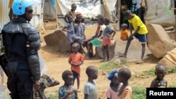 Enfants sous la protection d'un casque bleu dans un camp de déplacés à Juba, au Soudan du Sud, le 17 juin 2017.