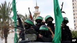 Masked militants from the Izzedine al-Qassam Brigades, a military wing of Hamas, ride vehicles as they commemorate the 30th anniversary of their group, in Gaza City, Dec. 13, 2017. 
