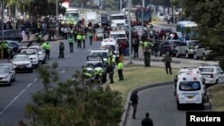 La policía y el personal de seguridad trabajan en el lugar donde explotó un coche bomba, según las autoridades, en Bogotá.