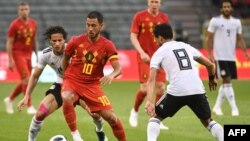 Pemain penyerang dari timnas sepak bola Belgia, Eden Hazard (tengah) berebut bola dengan gelandang Mesir, Tarek Hamed (kanan), dalam pertandingan persahabatan antara Belgia dan Mesir di Stadion King Baudouin di Brussels, Belgia, 6 Juni 2018.