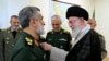 Iran's Supreme Leader Ayatollah Ali Khamenei (R) decorates, Oct. 6, 2024, the Islamic Revolutionary Guard Corps' Aerospace Force Commander Brigadier General Amir Ali Hajizadeh (L) with the 'Fath' badge in Tehran for planning the Iranian attack on Israel.