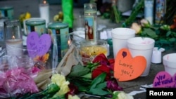 Candles burn as part of a memorial at the scene of Sunday morning’s mass shooting in Dayton, Ohio, Aug. 5, 2019.