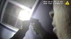 FILE - An officer shines a flashlight into a window in Fort Worth, Texas, in this Oct. 12, 2019, image made from a body camera video released by the Fort Worth Police Department.
