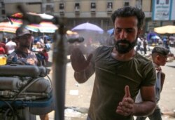 An Iraqi man uses a curbside shower to cool off during a heat wave in Baghdad, June 14, 2019. But even by Iraq standards, this June has been a sizzler averaging a daily 48 degrees Celsius (118 Fahrenheit), compared to around 40 typically.