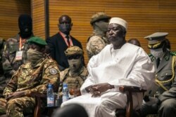 Former Defense Minister and retired Col. Maj. Bah N'Daw, right, is sworn into the office of transitional president, and Col. Assimi Goita, left, is sworn into the office of transitional vice president, at a ceremony in Bamako, Mali, Sept. 25, 2020.