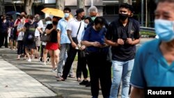 People queue up outside a quick test centre to take their coronavirus disease (COVID-19) antigen rapid tests, in Singapore September 21, 2021.

