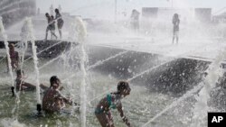 People bathe at a fountain escaping the heat wave, in St.Petersburg, Russia, July 27, 2019. 