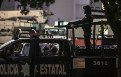 Mexican police patrol in a street of Culiacan, state of Sinaloa, Mexico, Oct. 17, 2019, after heavily armed gunmen in trucks fought an intense battle with Mexican security forces.