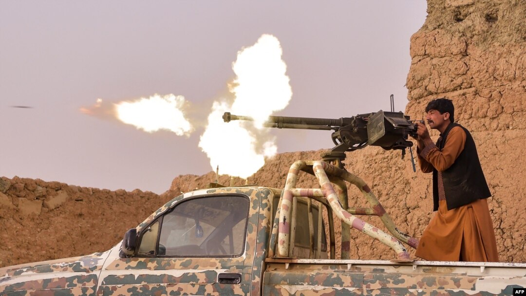 Seorang anggot milisi anti-Taliban menembakan senapan mesin dalam baku tembak dengan pemberontak Taliban di Mukhtar, pinggiran Lashkar Gah, Afghanistan, 28 Maret 2021. 