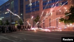 FILE - Fireworks explode near a group of law enforcement officers during a protest against the death in Minneapolis police custody of African-American George Floyd, in St Louis, Missouri, June 1, 2020.