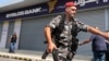 یک نیروی امنیتی در لبنان بیرون یک بانک تعطیل