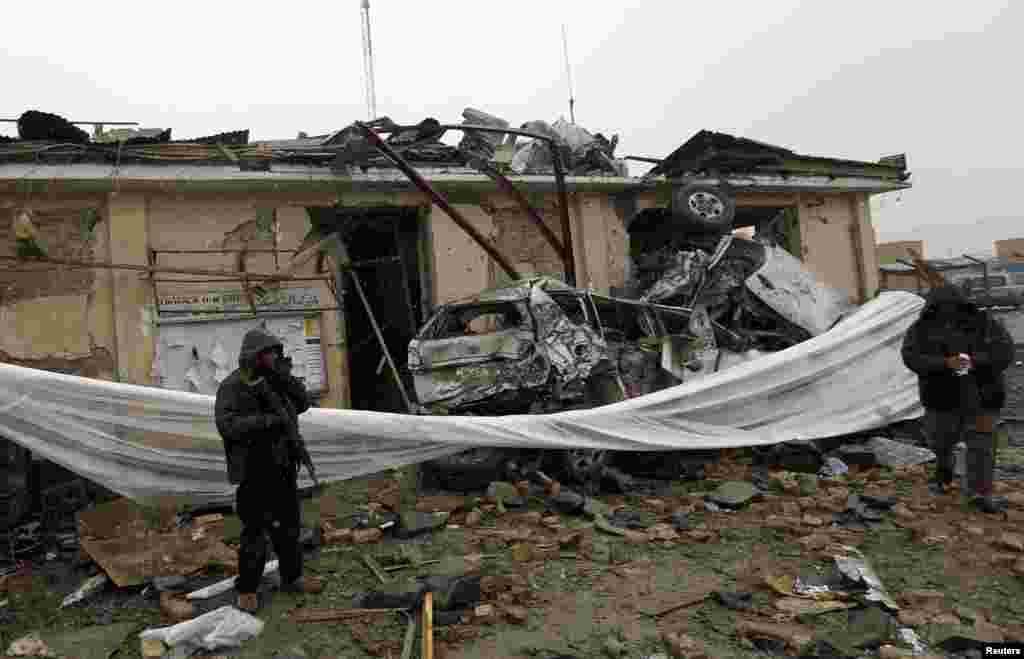 A security officer stands at the site of a blast in Kabul, Afghanistan, December 17, 2012.