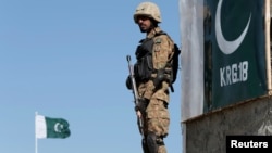 FILE - A Pakistani soldier stands guard at the Angoor Adda outpost along Pakistan's border with Afghanistan, in South Waziristan, Pakistan Oct. 18, 2017.