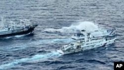 菲律宾海岸警卫队发布照片显示，中国海警船向菲律宾海岸巡逻艇发射水炮。（2023年12月10日）