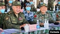 El ministro de Defensa ruso, Sergei Shoigu, izquierda, y su homólogo chino, Wei Fenghe, observan un ejercicio militar conjunto realizado en la Región Autónoma de Ningxia Hui en el noroeste de China, el 13 de agosto de 2021.