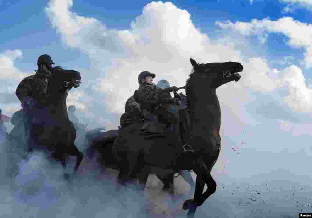 Members of the Dutch Royal Guard of Honour guide their horses through thick smoke during a rehearsal ahead of the Dutch 2014 budget presentation, at the beach of Scheveningen, Netherlands. 