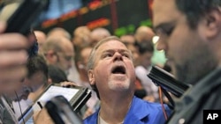 Traders work in the oil options pit at the New York Mercantile Exchange in New York City, where economic fallout from the massive earthquake that struck off the east coast of Japan dipped oil below $100 for the first time this month, March 14, 2011