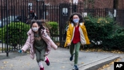 Para siswa tampak mengenakan masker saat meninggalkan sekolah mereka di kawasan Lower East Side, Manhattan, New York, pada 21 Desember 2021. New York akan mencabut mandat masker di lingkungan sekolah pada 2 Maret 2022. (Foto: AP/Brittainy Newman, File) 