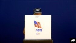 A voter fills out a ballot at a polling place at Lake Shore Elementary School, Nov. 6, 2018, in Pasadena, Maryland. 