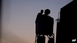 FILE - A Palestinian man checks the water tank on the roof of his home after water supply was cut in the village of Salem near the West Bank city of Nablus, June 18, 2016. Palestinians in the West Bank have long faced shortages of water in the summer months. 