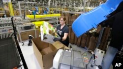 A worker places an item in a box for shipment,at a Amazon.com fulfillment center in DuPont, Washington. 