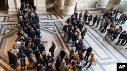 FILE - People queue as police controls everybody who wants to enter the Palace of Justice in Brussels, Jan. 16, 2015. 