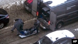 Workers load a body of Lt. Gen. Igor Kirillov, head of Russia's nuclear, biological, and chemical defense forces, into a bus after he and his assistant were killed by an explosive device in Moscow, Russia, Dec. 17, 2024. 